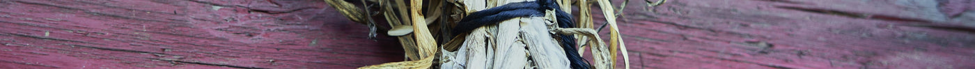 Garlic bundles hanging on a red barn wall to cure and dry after harvest